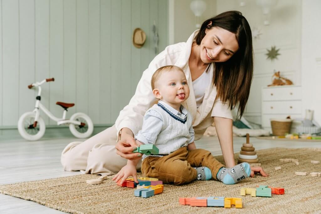 Mother smiling to her son while he´s playing with some sensory toys