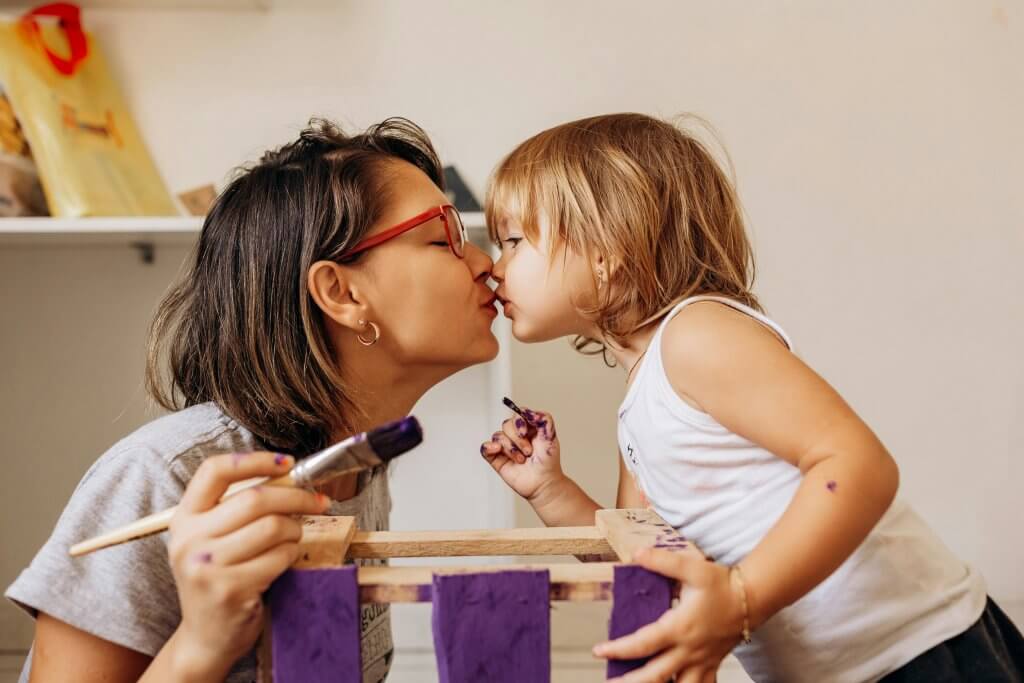 A mother and daughter creating a sensory play idea, like painting a box